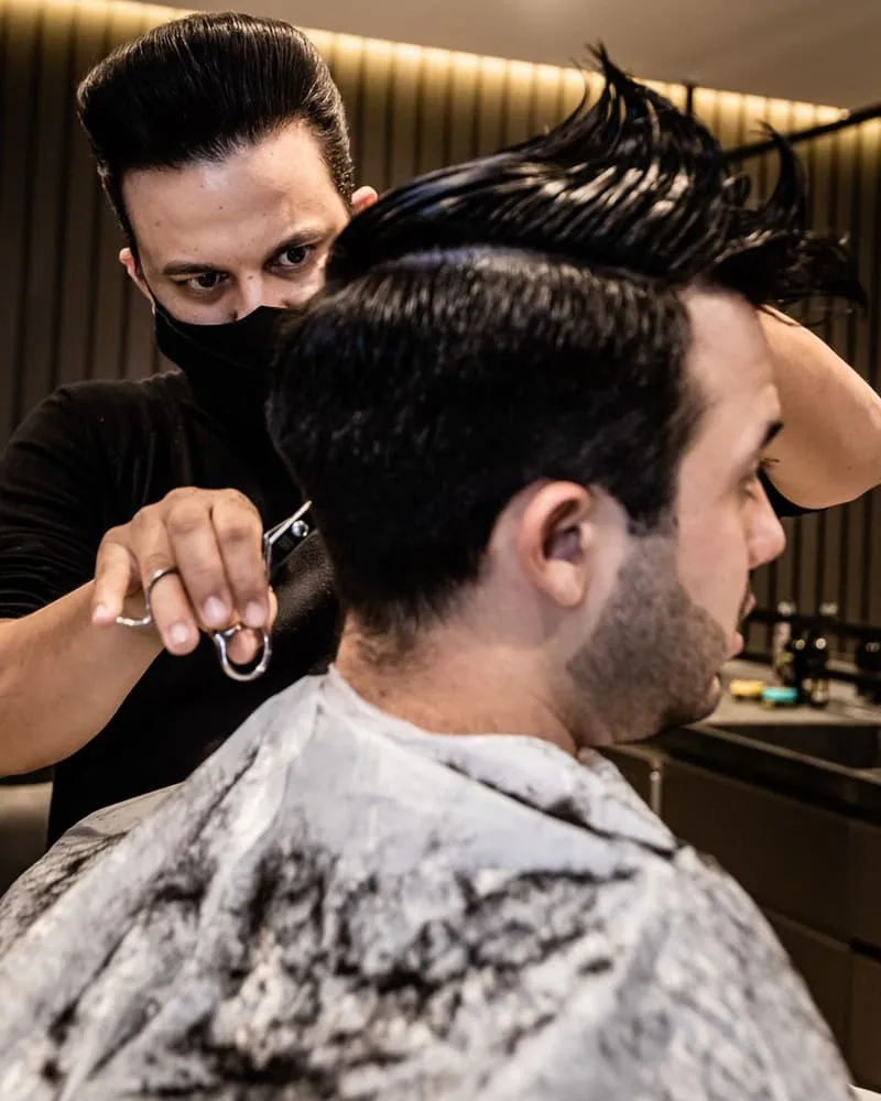 Coiffeur réalisant une coupe dans son salon Coiffeur réalisant une coupe dans son salon